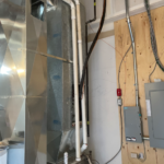 Picture of Furnace, AC lines running outside, & an electrical panel to the right. Done by HVAC company: Relica comforts
